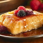 Serving sourdough French toast casserole with maple syrup and berries.